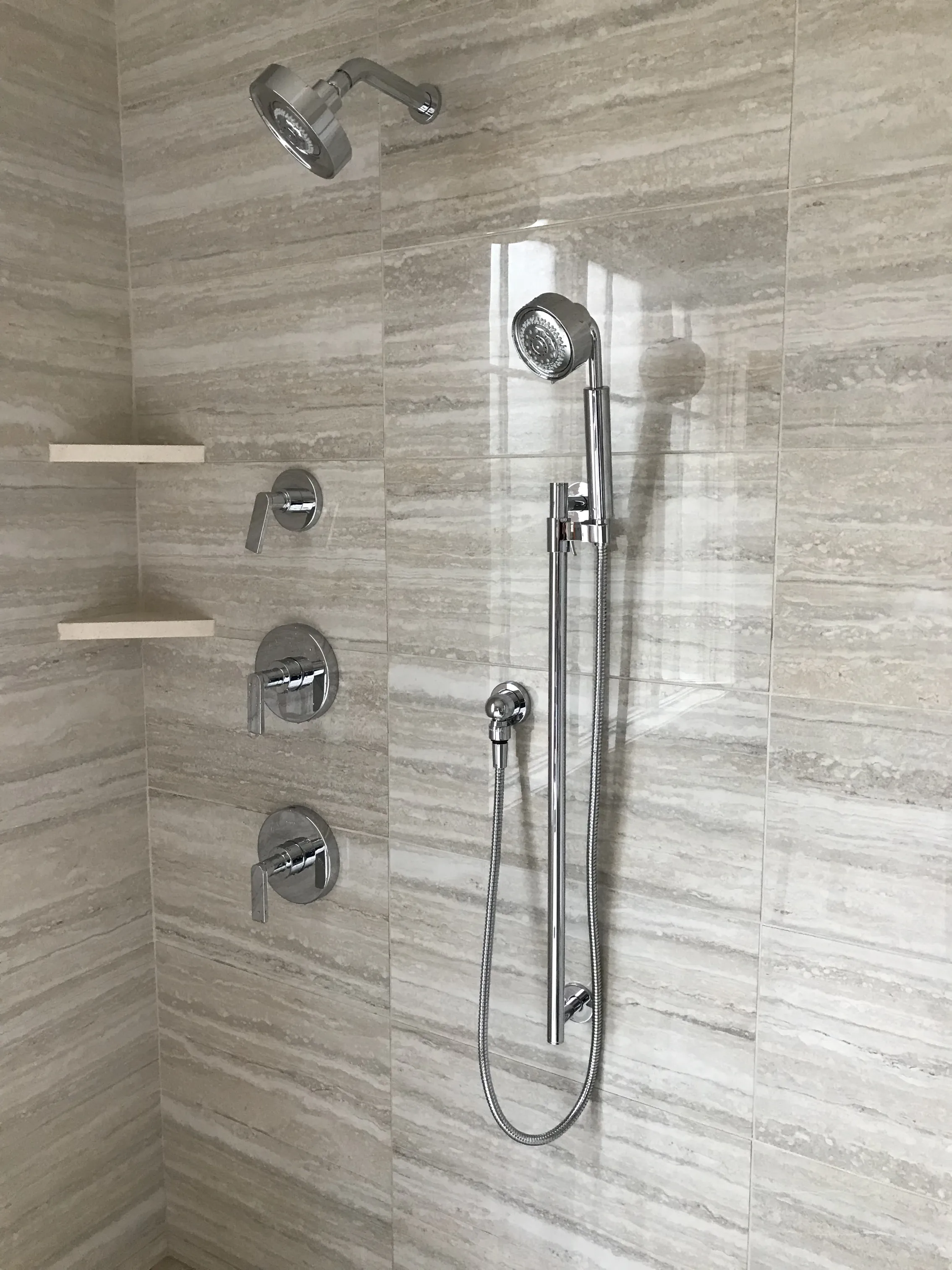Custom shower system with chrome fixtures and marble tile