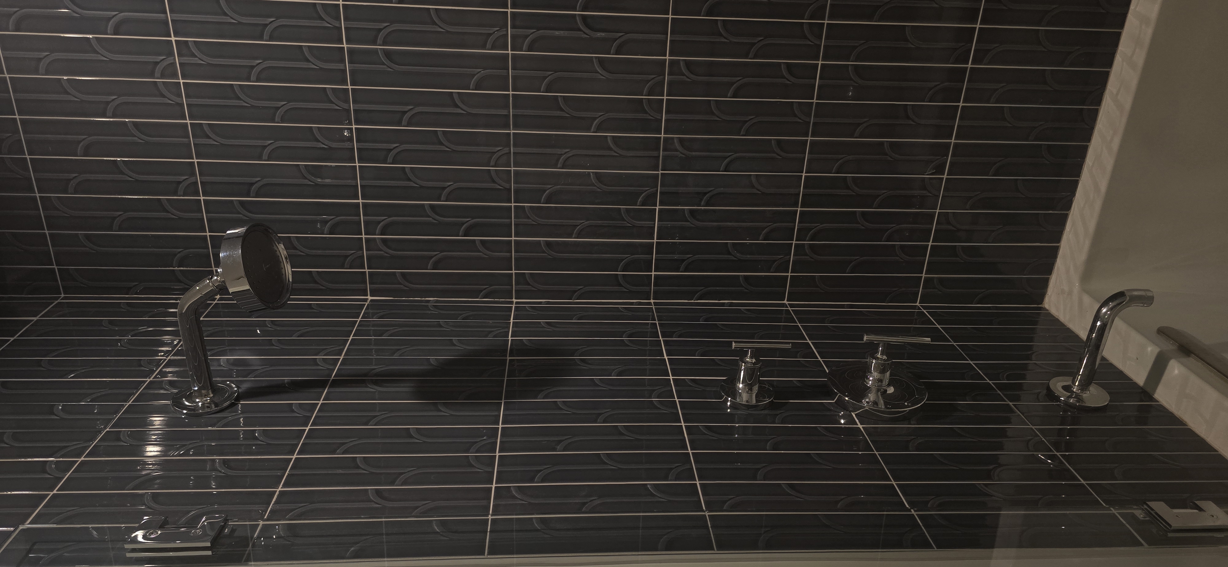 Black tile shower with chrome fixtures