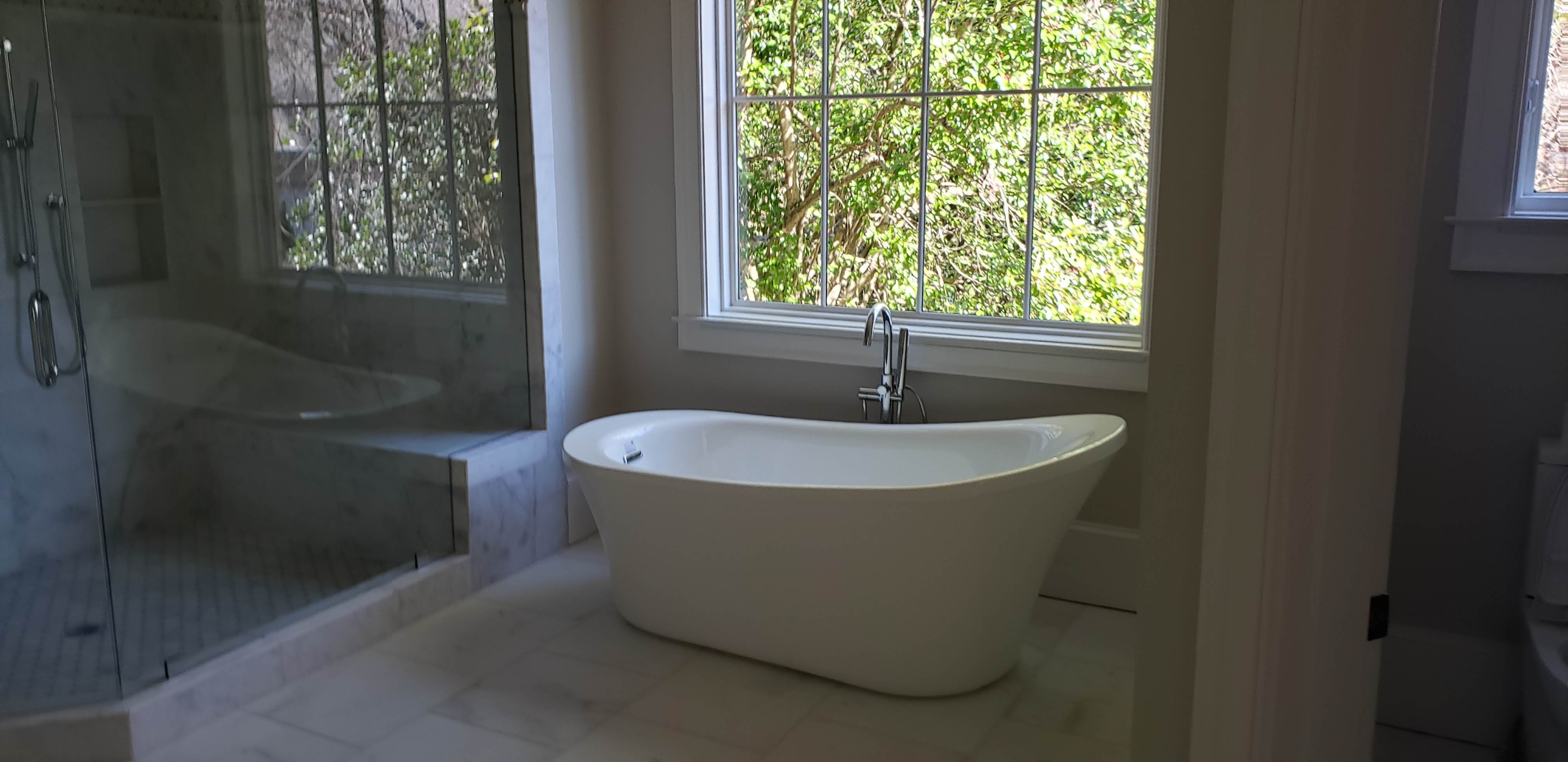 Freestanding soaking tub with glass shower enclosure