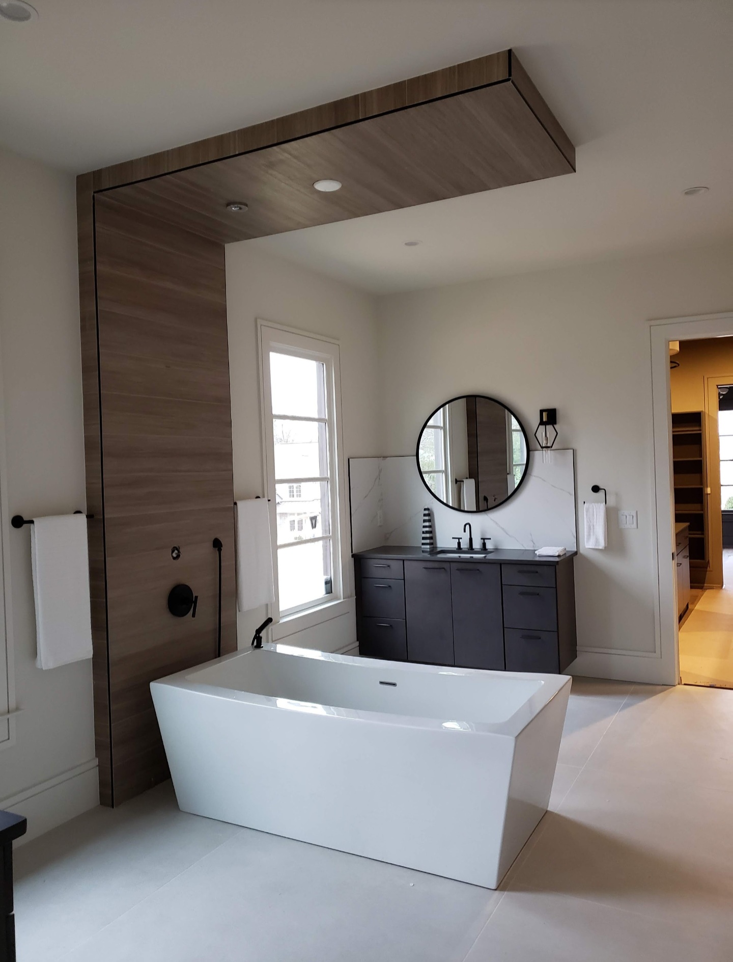 Modern freestanding rectangular tub with wood accent wall